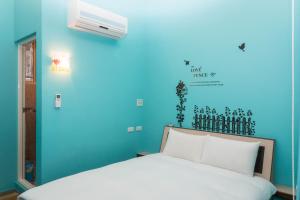 een blauwe slaapkamer met een wit bed en airconditioning bij Clover B&B in Yuchi