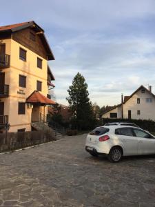 a white car parked in a parking lot next to a building at Apartment Linda in Zlatibor