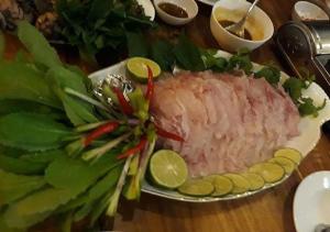 a plate of meat and vegetables on a table at Lucky Phu Quoc Hotel in Phú Quốc