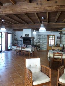 a dining room with tables and chairs and a fireplace at Maison d'hôtes Les 3 Baudets in Issor