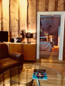 ein Wohnzimmer mit einem Bett und einem Glastisch in der Unterkunft Villa Friedrich in Bayreuth