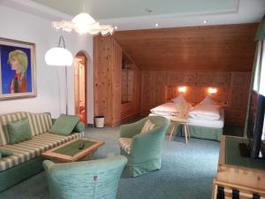 Pokój z 2 łóżkami i salonem z kanapą w obiekcie Hotel Garni Royal w Arabbie