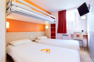 een hotelkamer met 2 bedden en een televisie bij Premiere Classe Tours Sud - Chambray Lès Tours in Chambray-lès-Tours