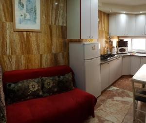a kitchen with a red couch in a room at Ezore Yam Apartmens - Elmali'akh St. 4 in Bat Yam