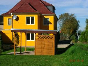 ein gelbes Haus mit einem Tor im Hof in der Unterkunft Ferienhaus Meier in Struppen