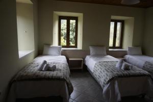 two beds in a room with two windows at Haus Kleopatra in Leonidion +26 photos