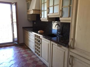 a kitchen with white cabinets and a black counter top at Casa Rural de Jaime in Medinaceli