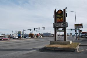 un cartello per una pizzeria sul lato di una strada di Plaza Inn a Great Falls