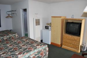 ein Hotelzimmer mit 2 Betten und einem TV in der Unterkunft Plaza Inn in Great Falls