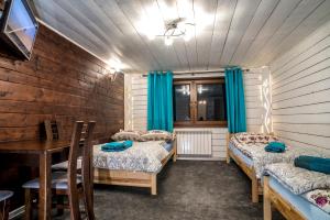 Habitación con 3 camas, mesa y sillas en Apartamenty Góraleczka z widokiem- pokój zabaw, en Czarna Góra