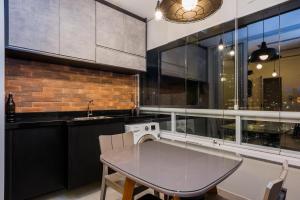 cocina con mesa de cristal y ventana en Residencial Be Paulista, en São Paulo