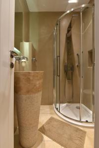 La salle de bains est pourvue d'une douche avec une porte en verre. dans l'établissement Kalypso Villas, à Náoussa