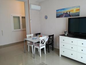 a dining room with a table and a tv at La Casa del Professore in Santa Teresa di Riva
