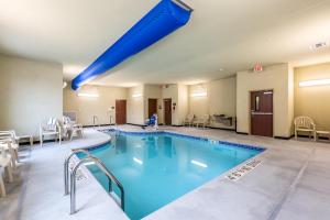 a pool in a hotel room with a blue swimming pool at Cobblestone Hotel & Suites - Stevens Point in Stevens Point
