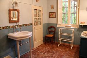 baño con lavabo y silla en B&B La Vagabonde, en Arles