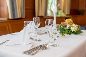 a table with wine glasses and a vase of flowers at Pfaffinger Hof in Pfaffing