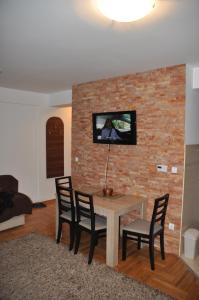 sala de estar con mesa, sillas y pared de ladrillo en Apartment Kiki, en Zlatibor