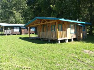 a wooden cabin with a blue roof in a field at Cabaña Pucon a Huife in Pichare