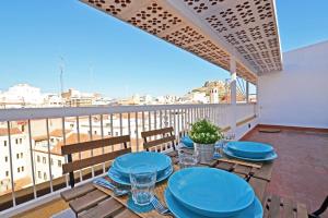 a table with blue plates on a balcony with a view at AticoColón21 in Alicante