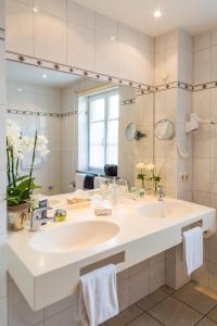 uma casa de banho com um grande lavatório branco e um espelho. em Pfaffinger Hof em Pfaffing