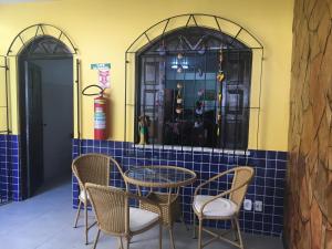 a table and chairs in a room with a window at Pousada do Sul in Ilhéus