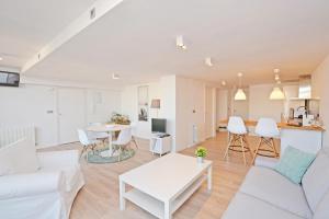 a living room with a white couch and a table at AticoColón21 in Alicante