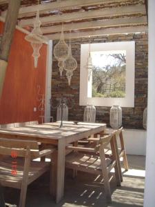 ein Holztisch mit Stühlen und Kronleuchtern in einem Zimmer in der Unterkunft Monte dos Binos in Porto Covo