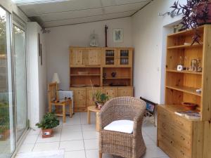 ラ・ロシェルにあるLa villa voyageの木製のキャビネット、椅子、テーブルが備わる客室です。