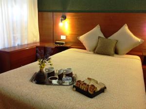 a bed with a tray of food and drinks on it at Apart Hotel Family in Mar del Plata
