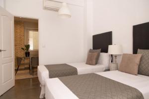 バレンシアにあるMD Oliag I Apartment Ruzafaのベッド2台とテーブルが備わるホテルルームです。