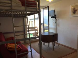 a room with a bunk bed with a table and a chair at Appartement Superbagnères in Superbagnères
