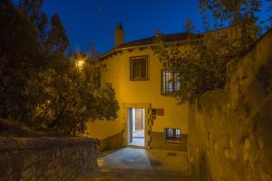 a large yellow building with a door at night at Apartamentos San Martin in Cuenca