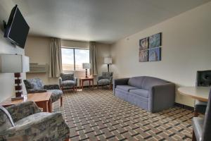 a hotel room with a couch and chairs and a table at Heritage Grand Inn in Canton