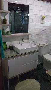 y baño con lavabo y aseo. en Casa Mágica, en Praia do Rosa