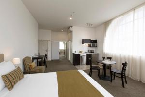 a hotel room with a bed and a kitchen at Quest Hamilton Serviced Apartments in Hamilton