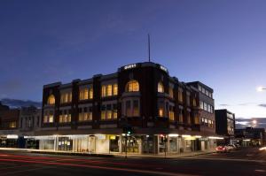 a building on the corner of a street at night at Quest Hamilton Serviced Apartments in Hamilton
