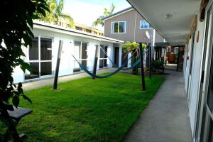 a yard with a blue hose attached to a building at Beachcomber Lodge & Backpacker in Kaitaia
