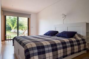 a bedroom with a bed with blue pillows on it at Casa de ferias em Caminha - Minho - in Caminha