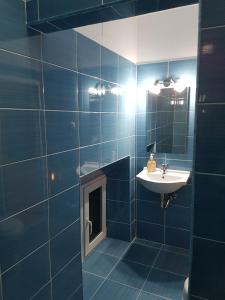 クルジュ・ナポカにあるVivaldi Studiosの青いタイル張りのバスルーム(シンク、鏡付)