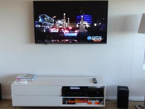 a flat screen tv hanging on a white wall at The Villa Dunsborough in Dunsborough