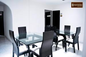 une salle à manger avec une table et des chaises en verre dans l'établissement Hotel Madeira, à Manizales