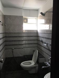 a bathroom with a toilet and a sink at Hotel Grand Suites in Bangalore