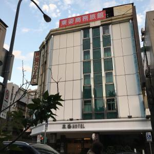 台北的住宿－東姿商務旅館，白色的建筑,上面有红色的标志