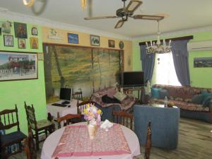 a living room with a table and chairs and a couch at Sandalis Hotel in Pythagoreio