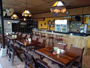 a restaurant with wooden tables and chairs and a bar at Bee Nat Garden Resort in Bangrak Beach