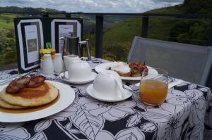 a table topped with plates of food and orange juice at Top Of The Hill in Maleny