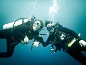 two people are posing for a picture while scuba diving at Hotel Brisa Mar in Santa Catalina