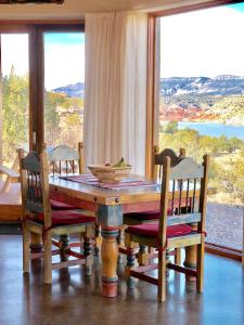 a dining room table with chairs and a large window at The Casita del Lago in Abiquiu