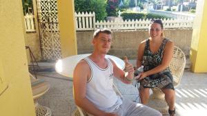 a man and a woman sitting in a chair at Leslies' Home in Portmore