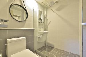 a bathroom with a toilet and a mirror at With U Hotel & Guesthouse in Sokcho